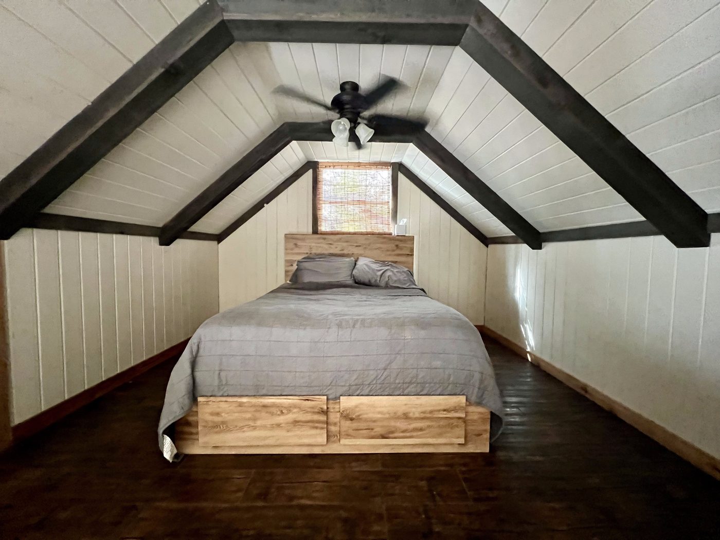 Loft bedroom with vaulted beamed ceiling and queen bed