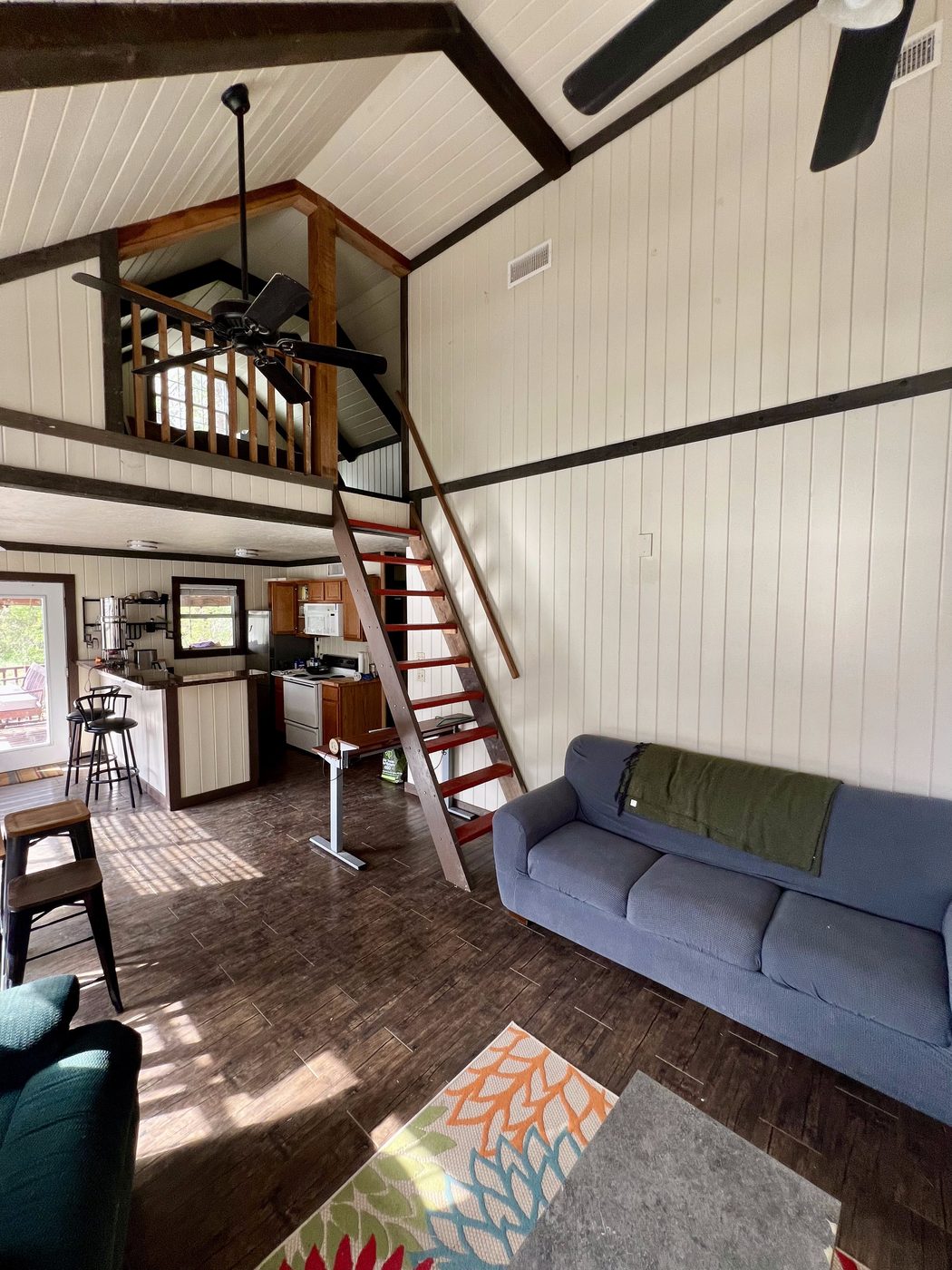 Open-plan living area showing loft staircase and kitchen beyond
